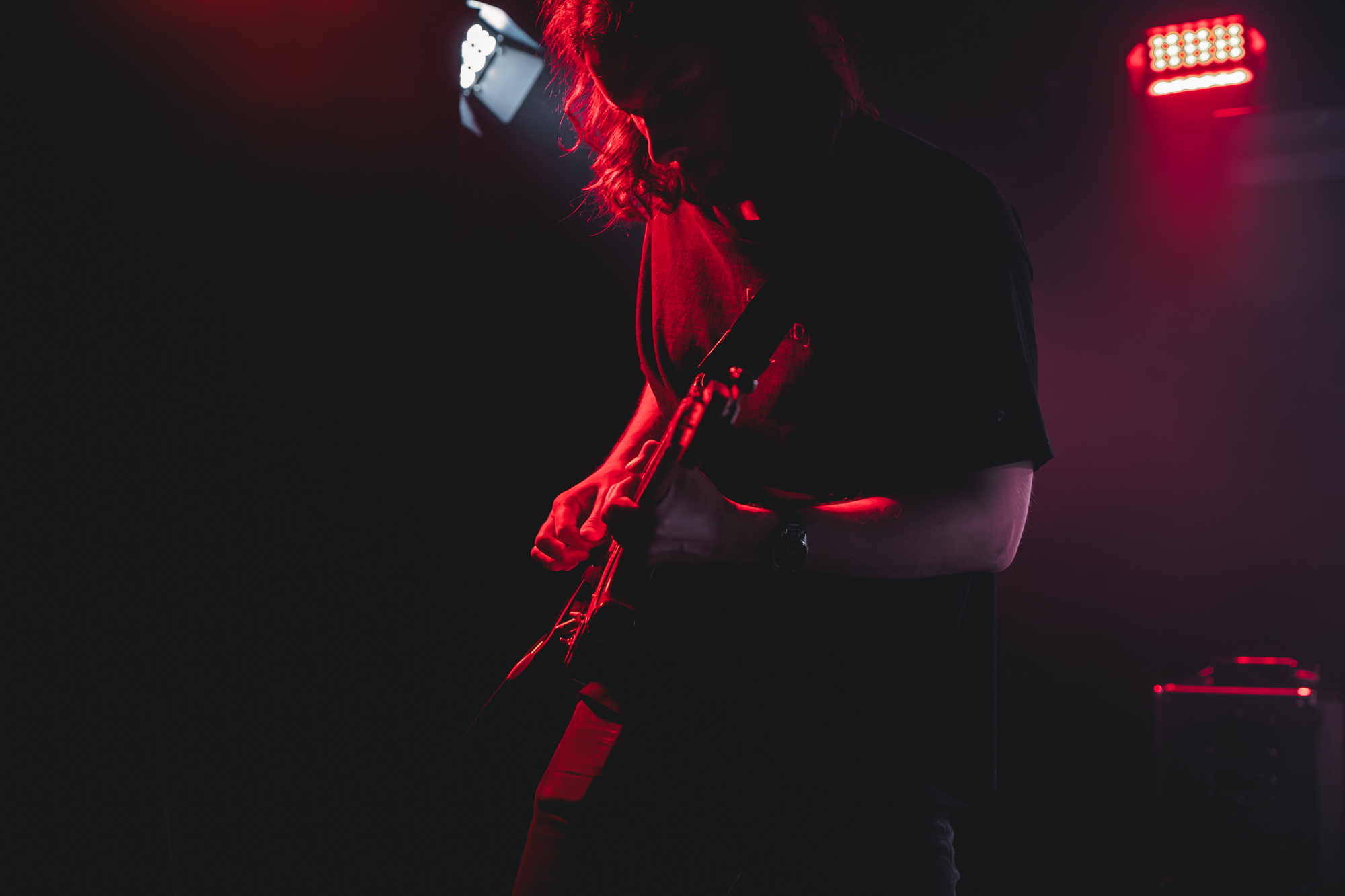 Solár live — guitarist bathed in red stage light